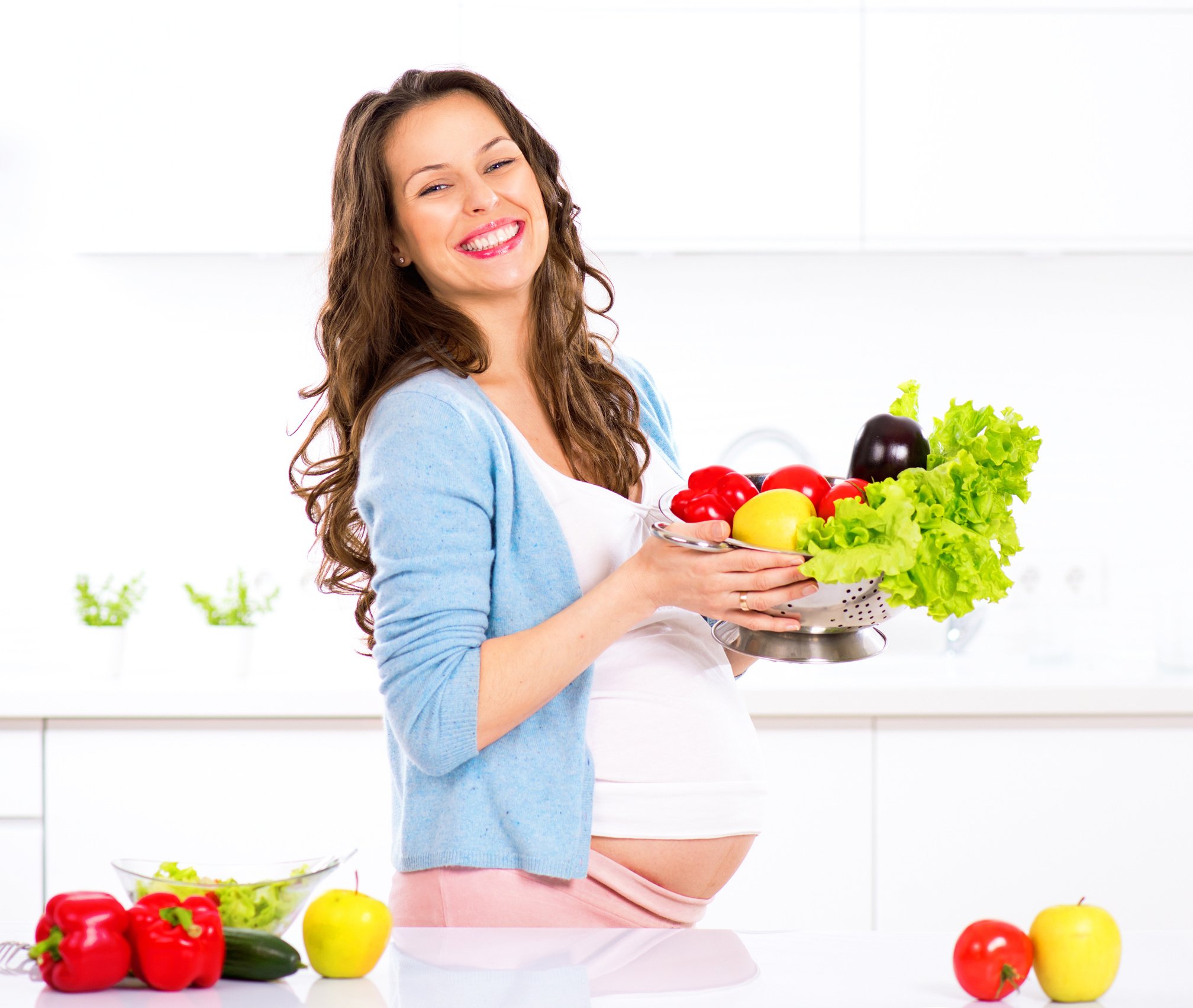 Pregnant Woman Cooking Vegetables in the Kitchen